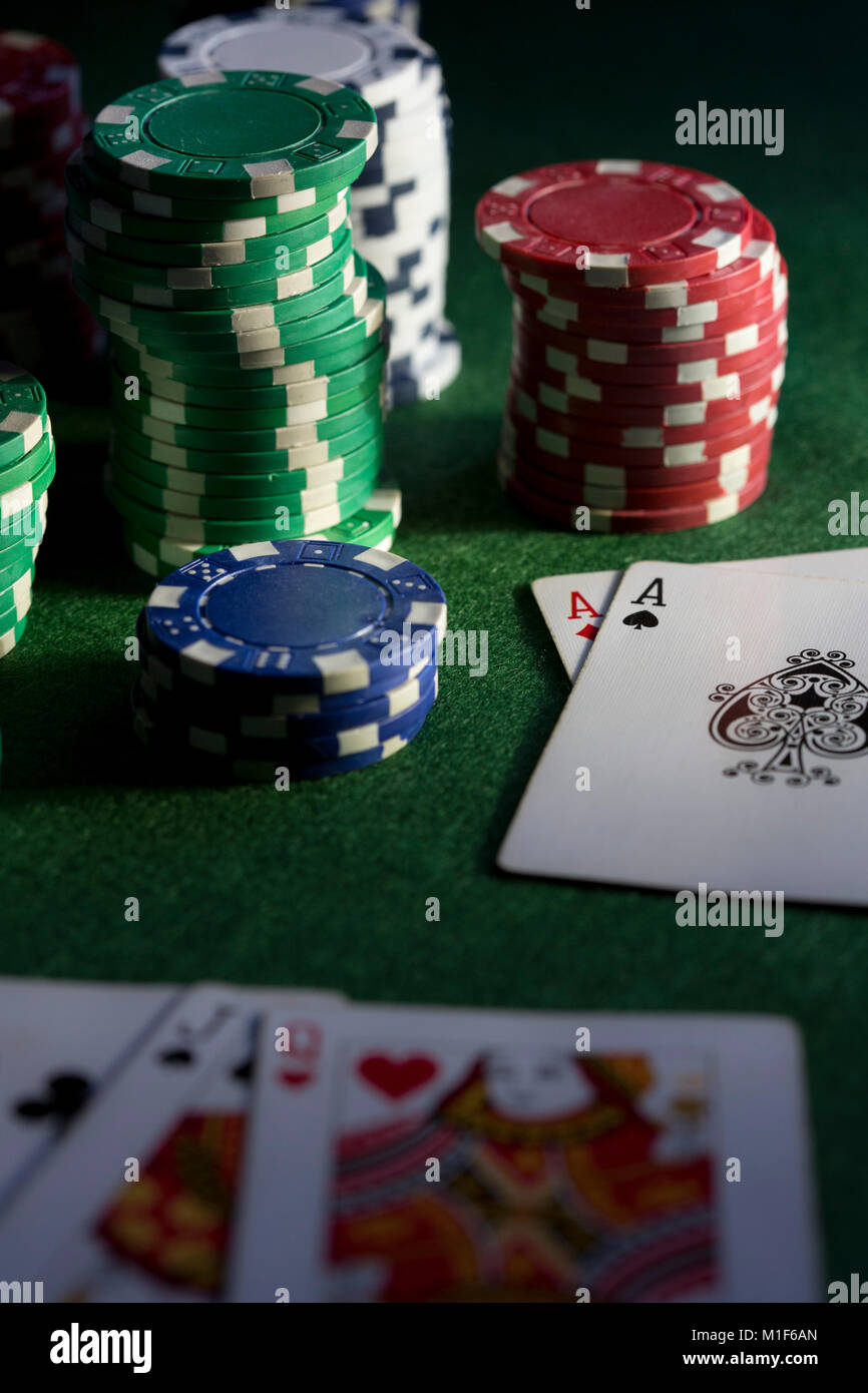 A green baize card table with chips and cards, stacks and piles of