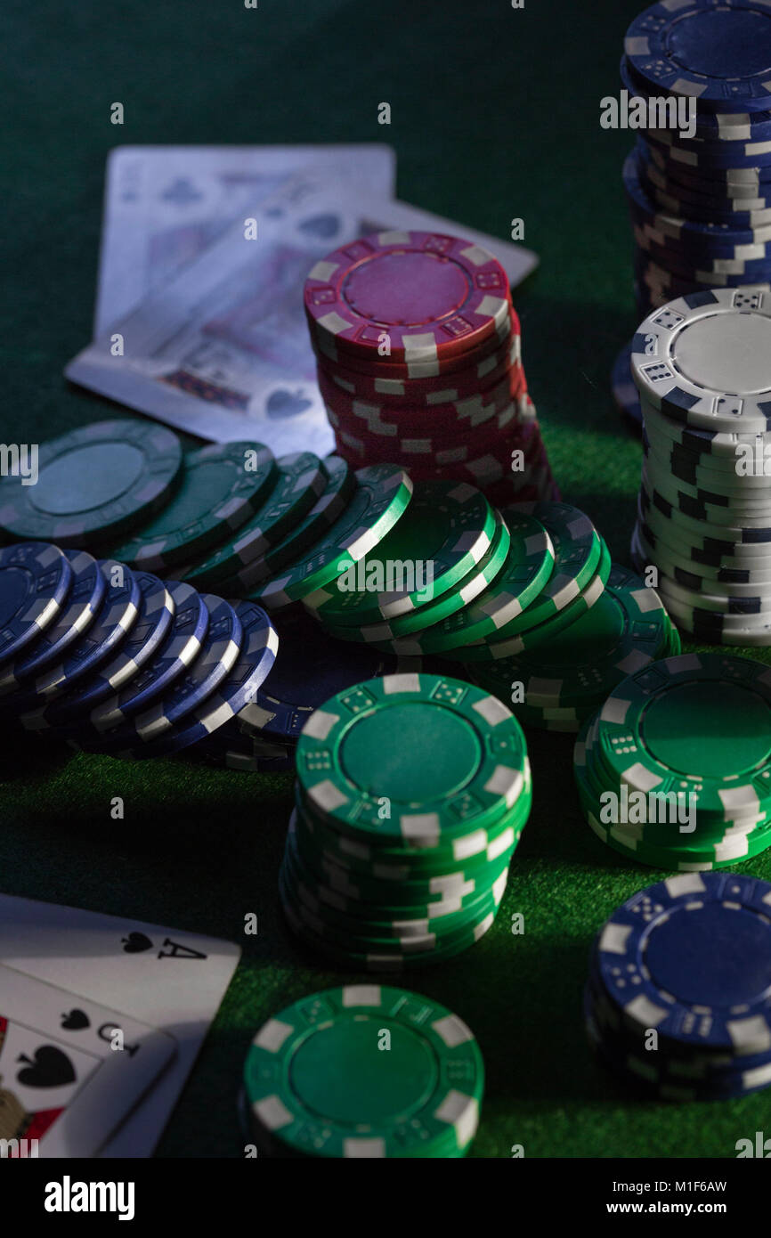 A green baize card table with chips and cards, stacks and piles of