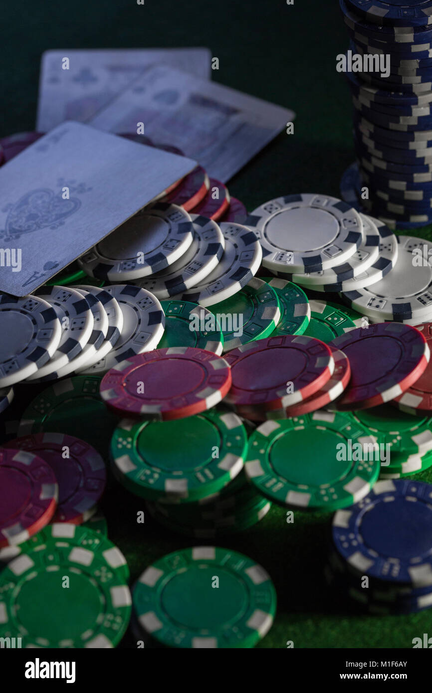 A green baize card table with chips and cards, stacks and piles of