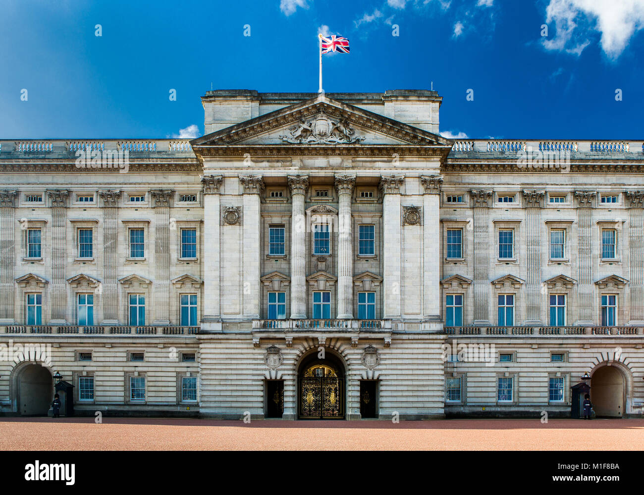 The facade of Buckingham Palace with the Union Flag flying against a clear blue sky. Stock Photo