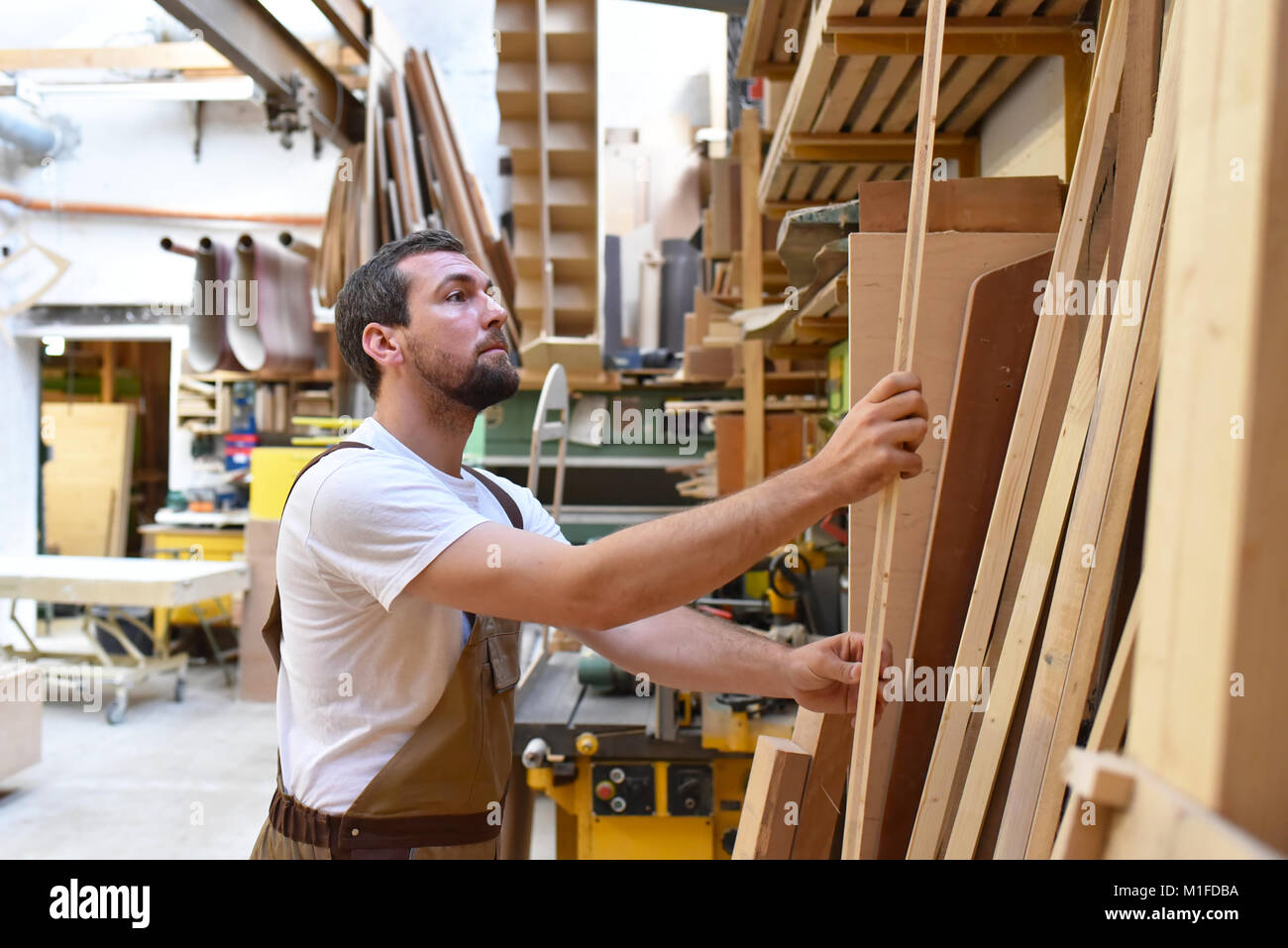carpenter works in a joinery for woodworking and sawing