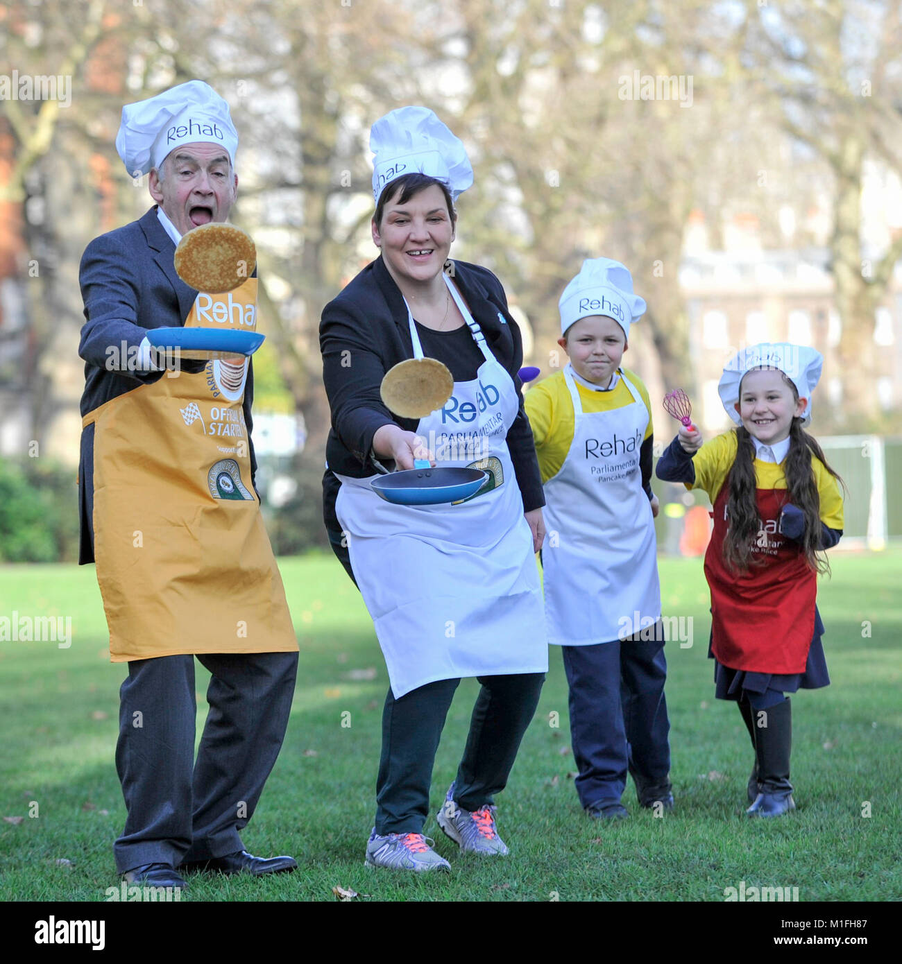 London, UK. 30th Jan, 2018. Race veteran and this year's Official Starter, ITV newscaster, Alastair Stewart OBE, oversees Tonia Antoniazzi MP for the Parliament Team, take part in a pancake race bootcamp in Westminster ahead of the main event, the Rehab Parliamentary Pancake Race, on Shrove Tuesday. They are joined by team mascots Grace and Jacob, both aged 8, from St Matthew's Primary School in Westminster. Credit: Stephen Chung/Alamy Live News Stock Photo