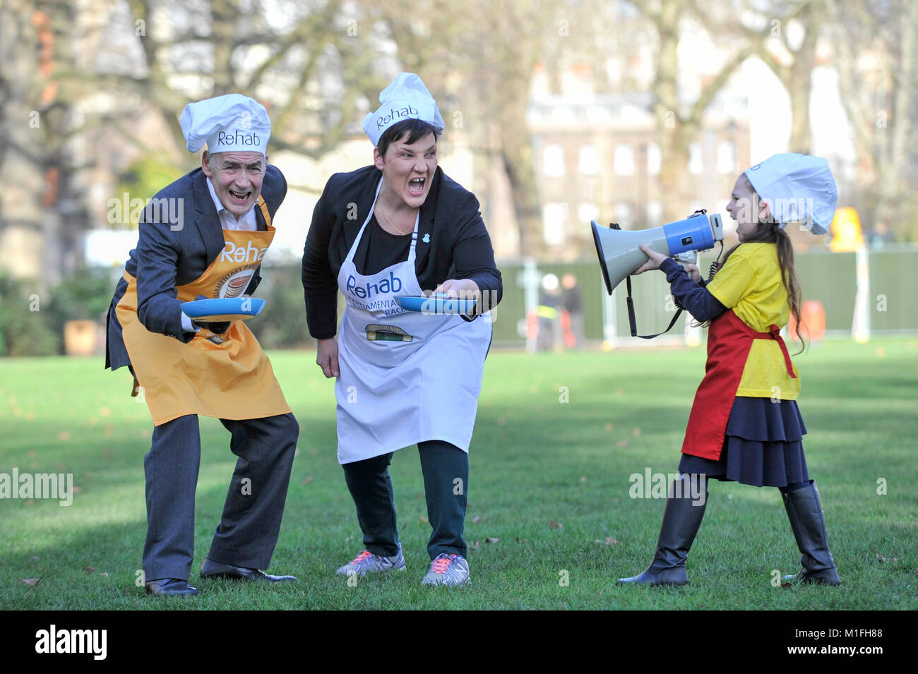 London, UK. 30th Jan, 2018. Race veteran and this year's Official Starter, ITV newscaster, Alastair Stewart OBE, oversees Tonia Antoniazzi MP for the Parliament Team, take part in a pancake race bootcamp in Westminster ahead of the main event, the Rehab Parliamentary Pancake Race, on Shrove Tuesday. Team mascot Grace aged 8, from St Matthew's Primary School in Westminster, offers encouragement. Credit: Stephen Chung/Alamy Live News Stock Photo