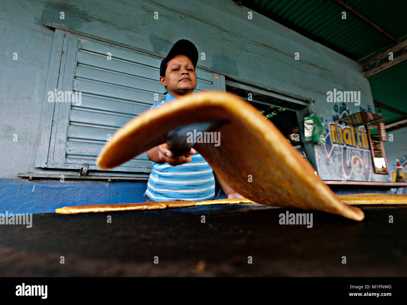 Maturin, Monagas, Venezuela. 8th Dec, 2012. december 09, 2012.A woman flips the cachapas in the budare that is a rudimentary kitchen of brick and clay, in the city of Matur'n, Monagas state, Venezuela.foto: Juan Carlos Hernandez Credit: Juan Carlos Hernandez/ZUMA Wire/Alamy Live News Stock Photo