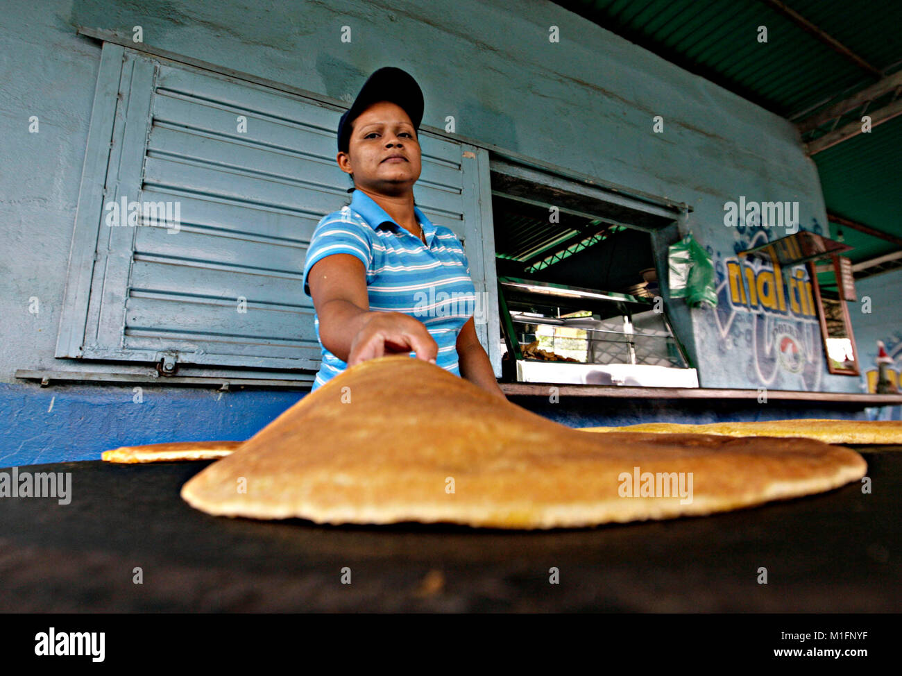 Maturin, Monagas, Venezuela. 8th Dec, 2012. december 09, 2012.A woman flips the cachapas in the budare that is a rudimentary kitchen of brick and clay, in the city of Matur'n, Monagas state, Venezuela.foto: Juan Carlos Hernandez Credit: Juan Carlos Hernandez/ZUMA Wire/Alamy Live News Stock Photo