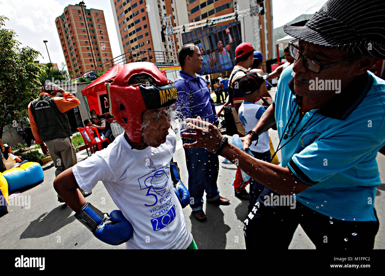 Naguanagua, Carabobo, Venezuela. 28th June, 2012. June 28, 2012. The trainer attends the corner throwing water on his face to his boxer from the boxing talents school of Naguanagua during a bout as a street exhibition, In Naguanagua, Carabobo state, Venezuela. Photo: Juan Carlos Hernandez Credit: Juan Carlos Hernandez/ZUMA Wire/Alamy Live News Stock Photo