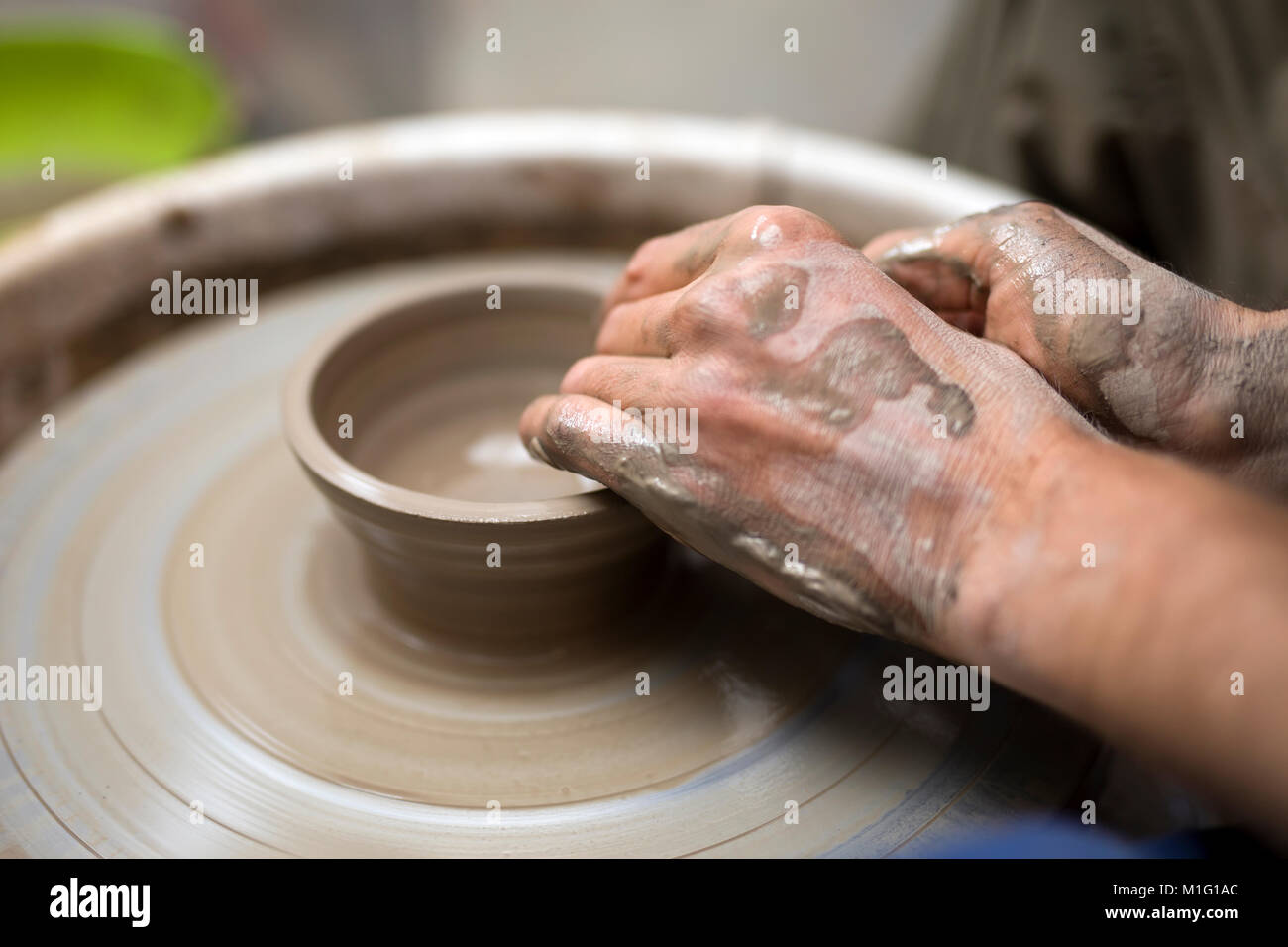 Close up detail view at an artist makes clay pottery on a spin wheel
