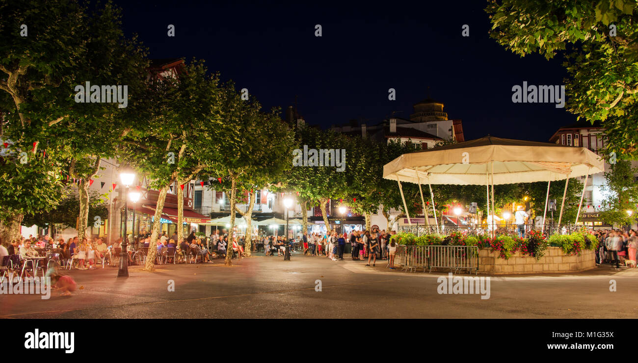 People on Place Louis XIV in summer at night, Saint de Luz, France Stock Photo