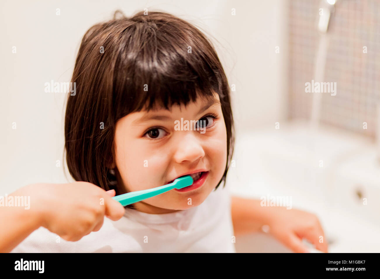 Portrait of little girl brushing teeth Stock Photo