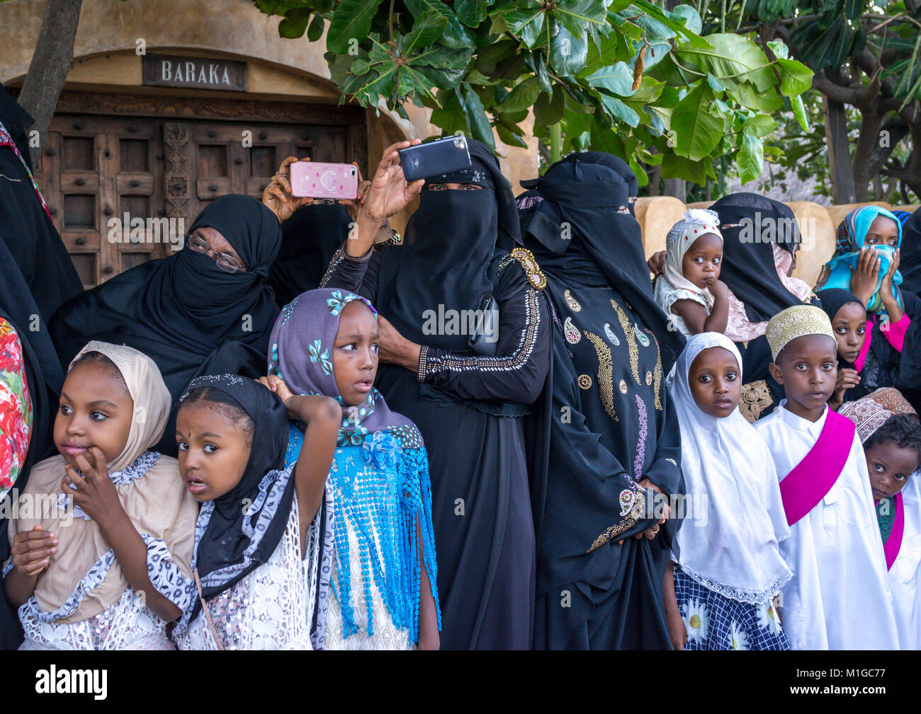Sunni muslim women taking pictures during the Maulidi festivities in the  street, Lamu County, Lamu Town, Kenya Stock Photo - Alamy