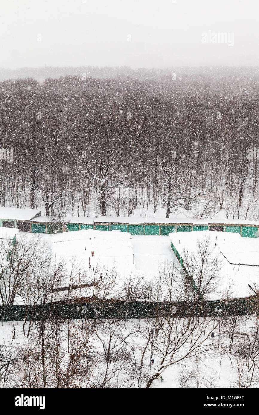 snowfall over woods and car garages in Timiryazevskiy park in Moscow ...