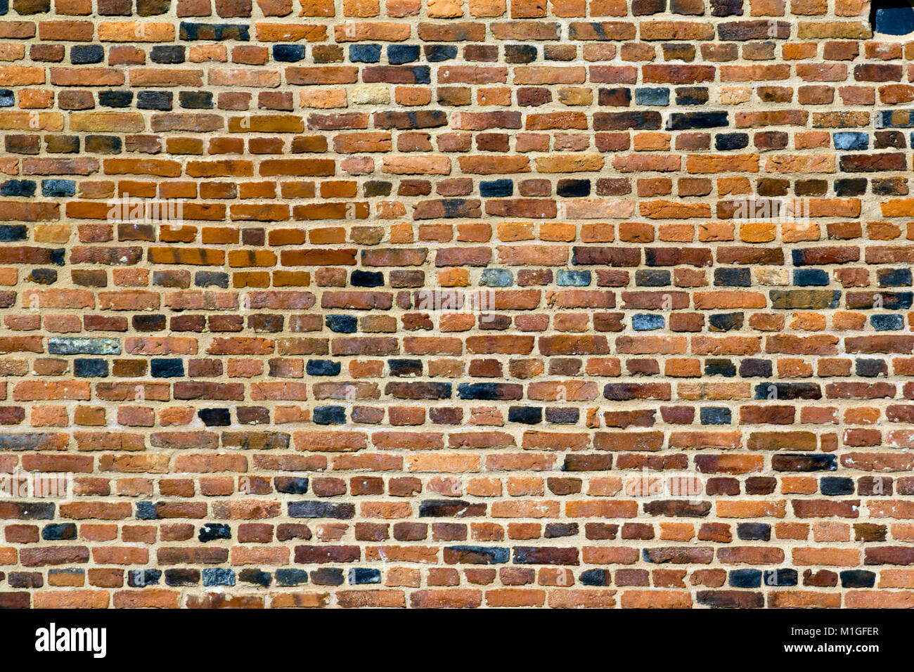 Old multi-coloured red brick wall full frame texture background Stock Photo