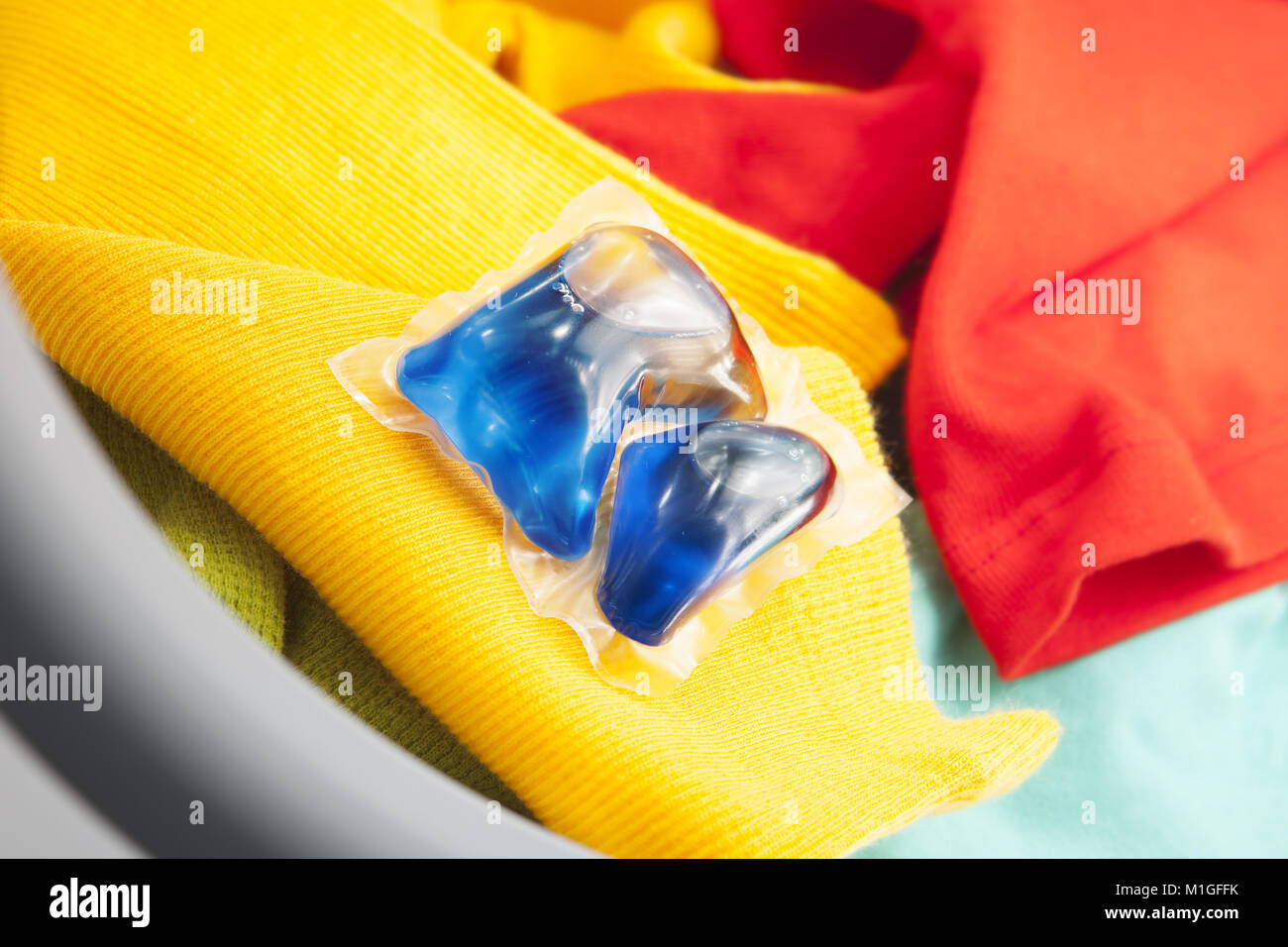 blue gel caps in washing mashine, liquid coloured detergent Stock Photo