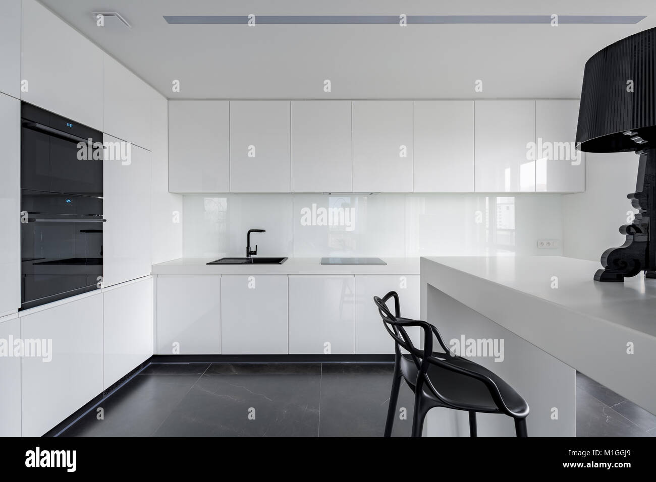 Sophisticated black and white kitchen interior with simple table and