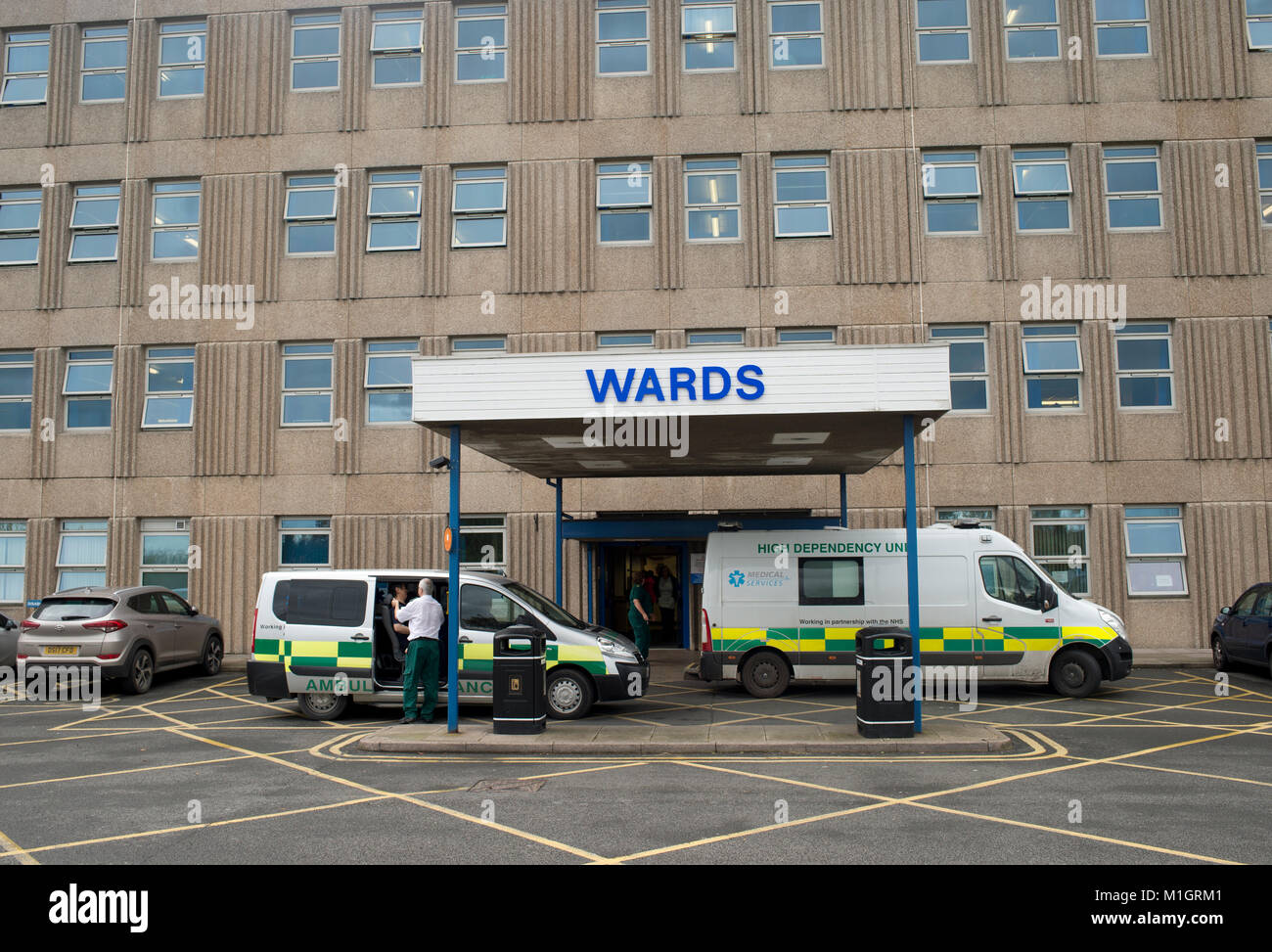 Two ambulances are parked outside Shrewsbury NHS hospital under a sign saying Wards Stock Photo