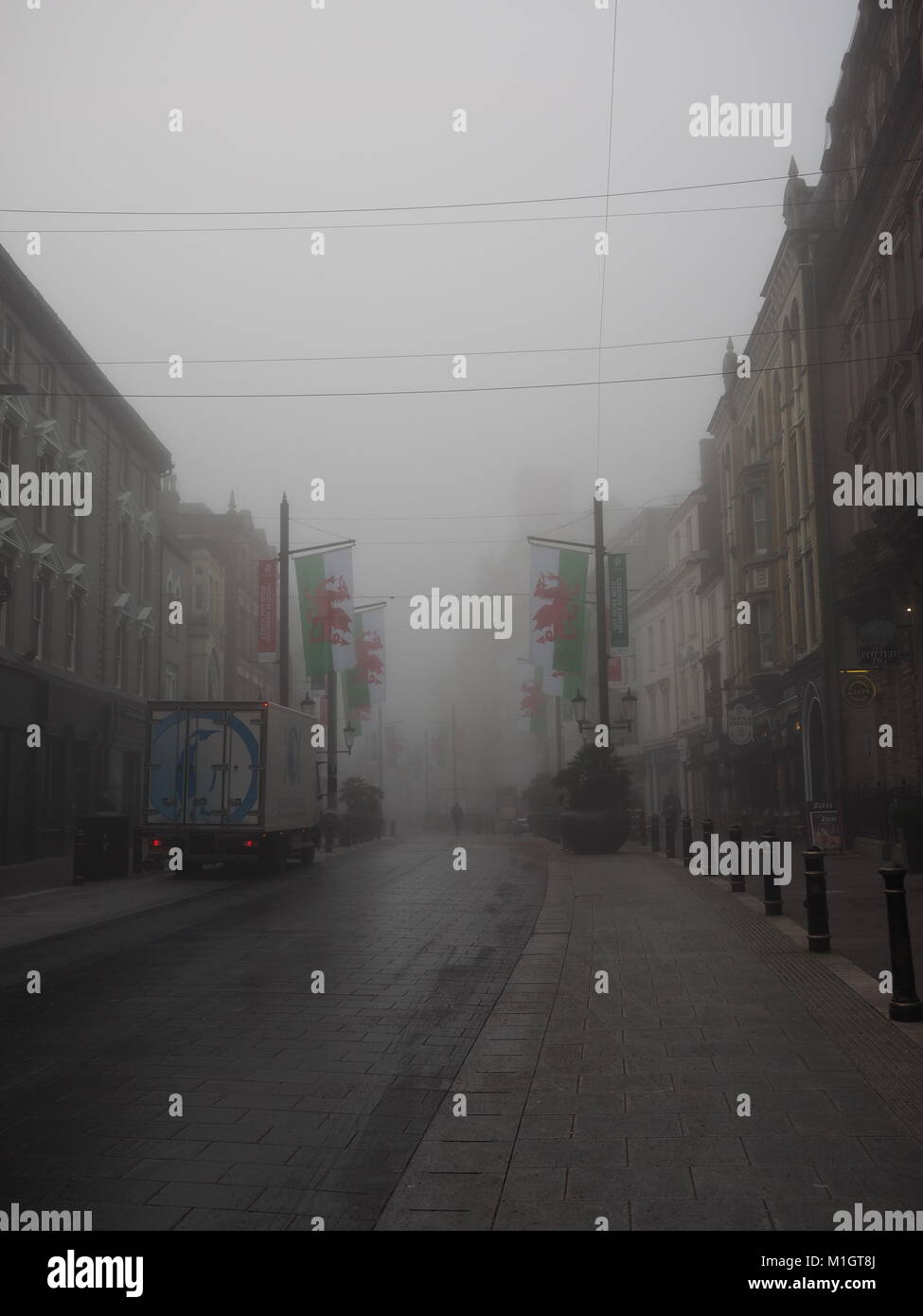 Commuters wend their way through the early morning fog on Cardiff's Mary Street, Wales Stock Photo