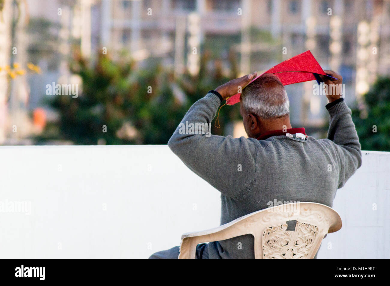 Jaipur, India - 14th Jan 2018: Old man bending a paper kite to improve it's aerodynamics. Kite flying is traditional on the festival of makar sankranti or uttaryan in Rajasthan and Gujarat india Stock Photo