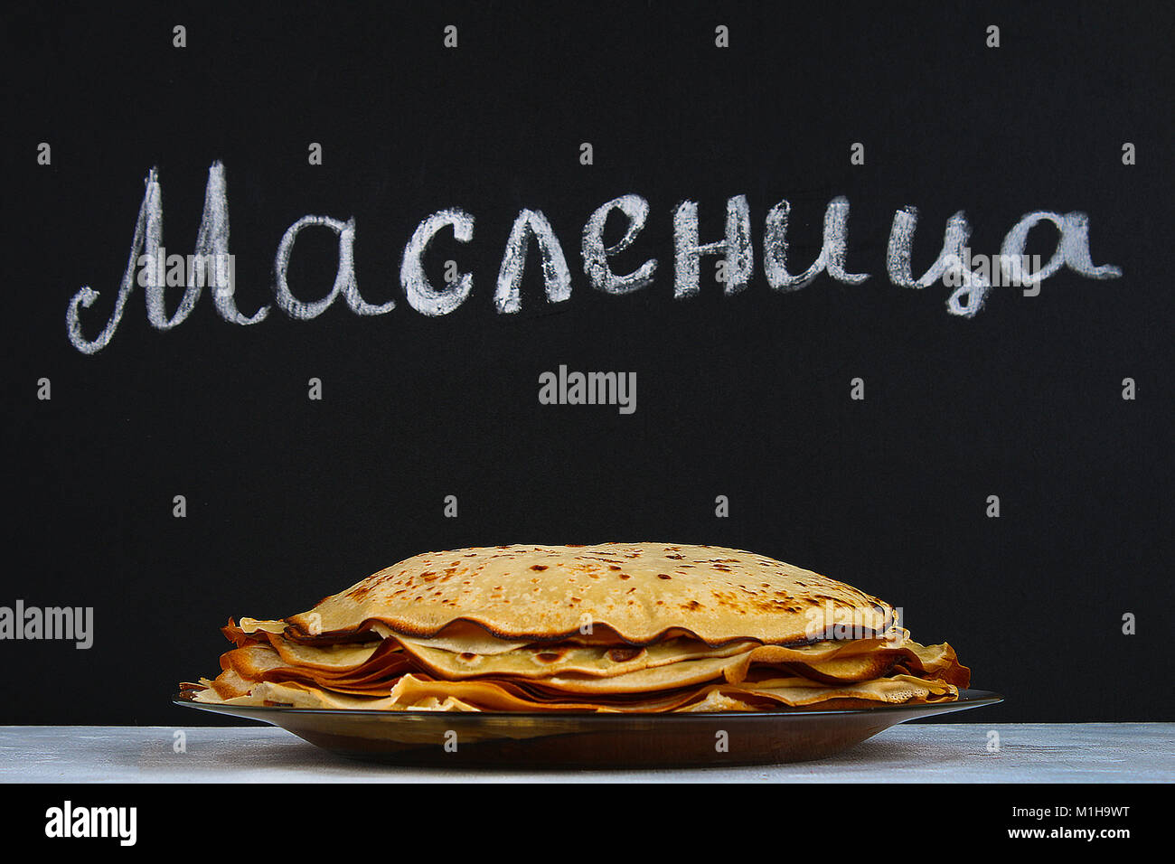The inscription on a chalkboard in Russian: Maslenitsa. Traditional Ukrainian or Russian pancakes. Traditional dishes on the holiday Carnival Maslenit Stock Photo