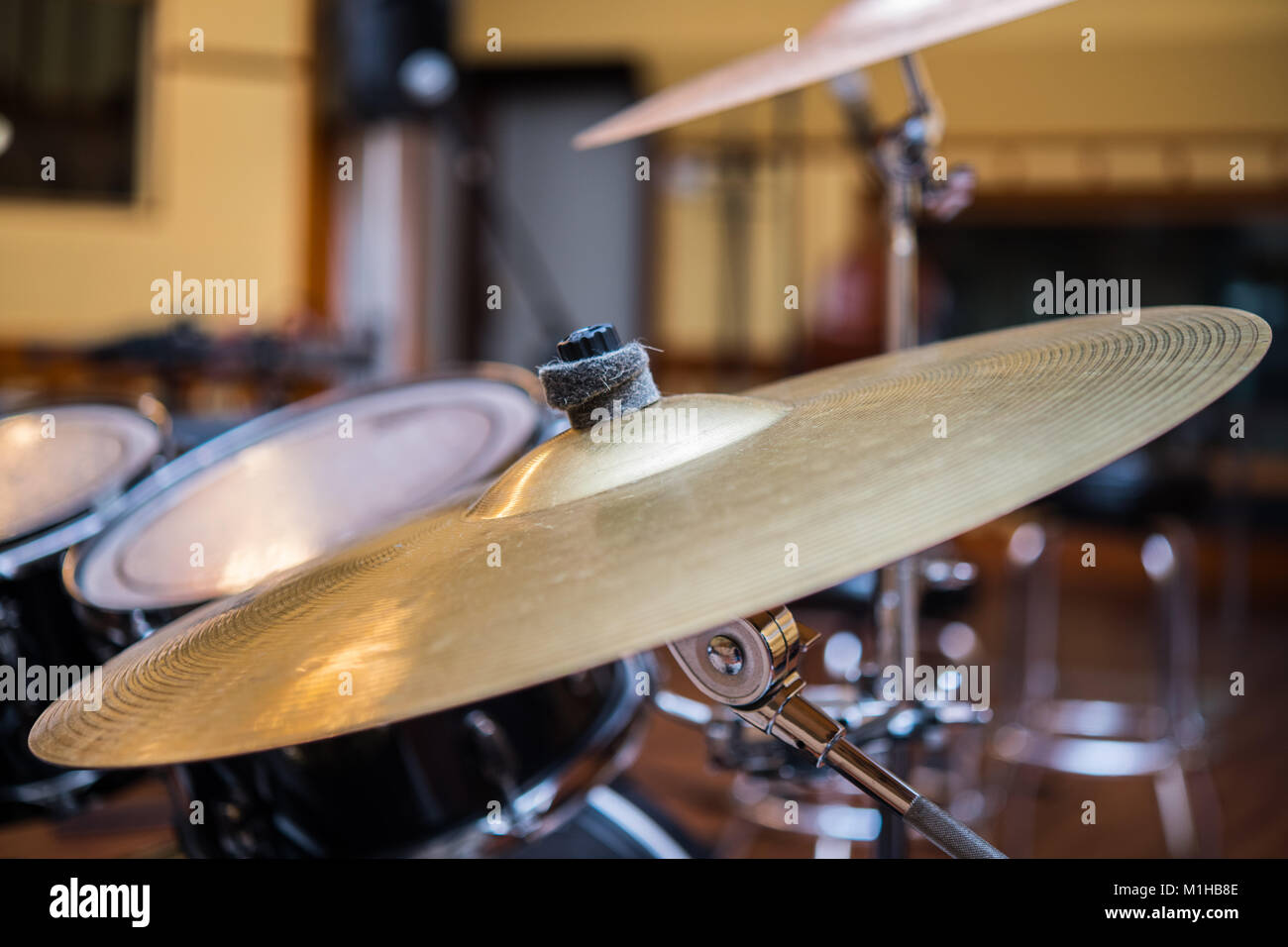 Close up of golden bronze cymbal plate part of drum set out of focus ...