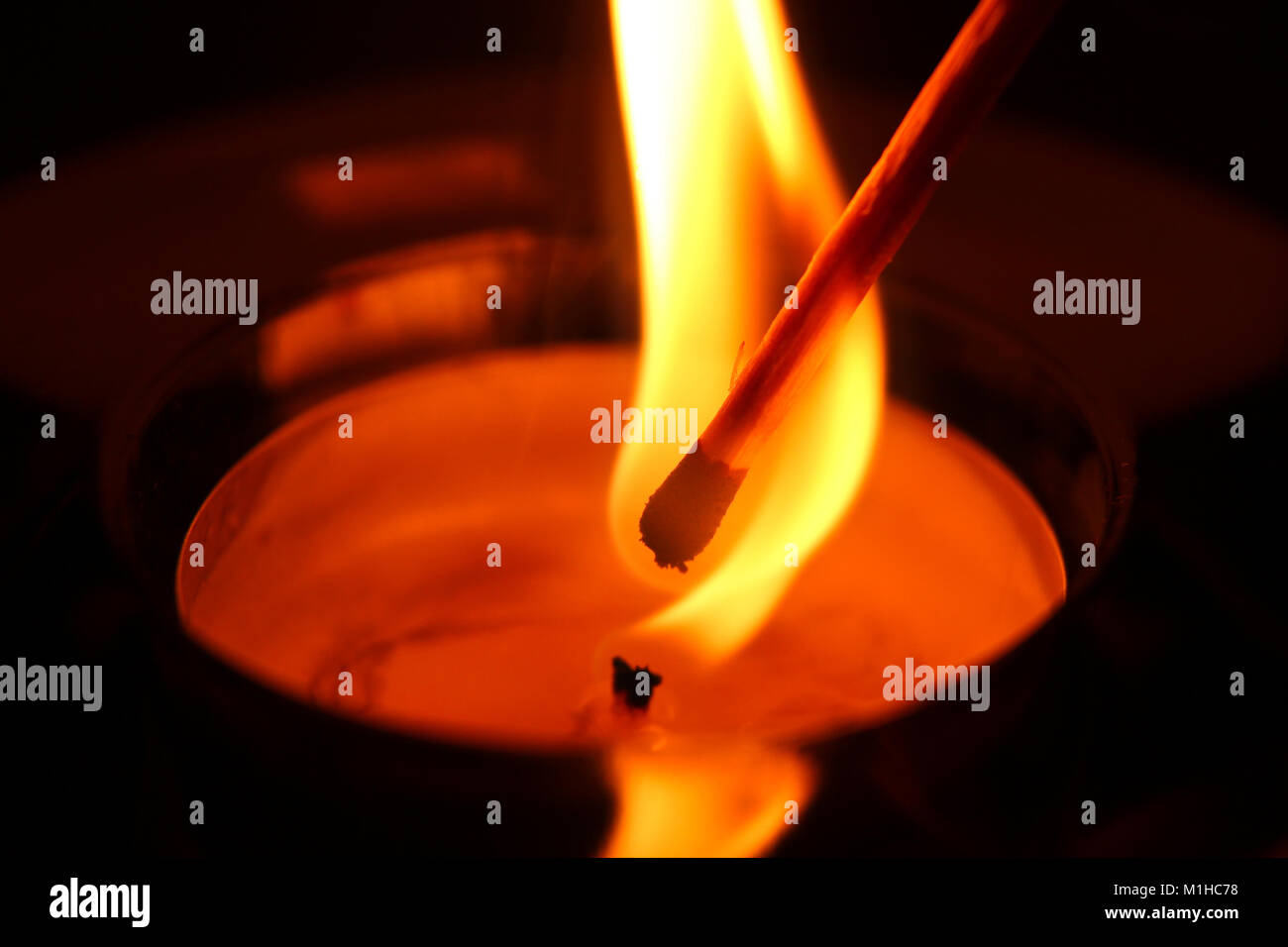 A candle is being lighted by the match. Stock Photo