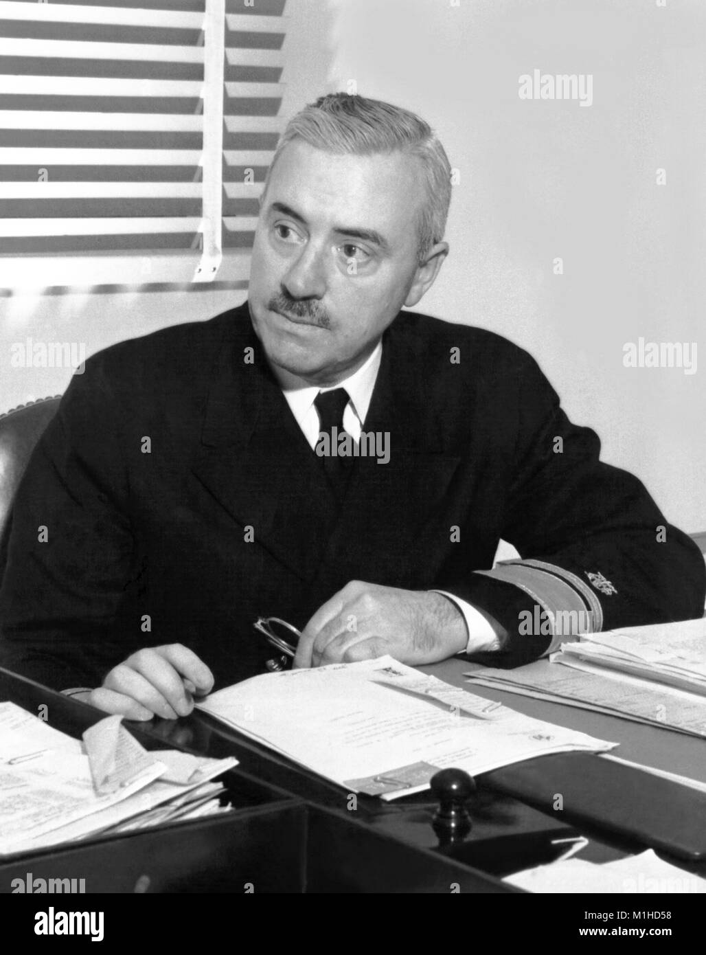 Photograph showing Thomas Parran, Jr. M.D. seated at a desk in an office setting, Parran as the sixth United States Surgeon General (1936-1948) took part in creating the modern American health system and debated the role of the national government in public health, and his legacy includes contributions in the field of venereal diseases research, 1956. Image courtesy CDC. () Stock Photo