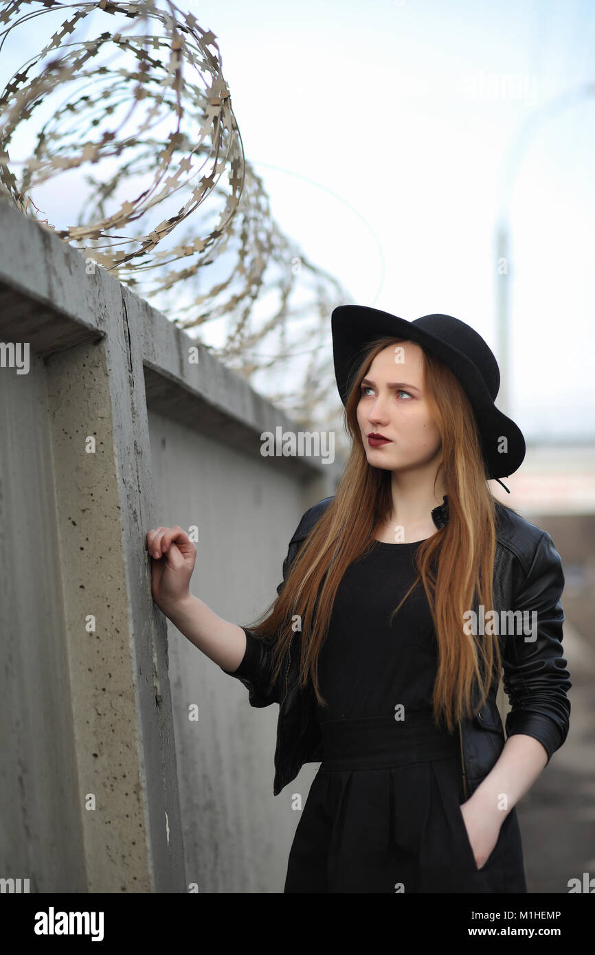 A Girl Walks Down The City Street In A Leather Waistcoat With A Stock a-girl-walks-down-the-city-street-in-a-leather-waistcoat-with-a-stock