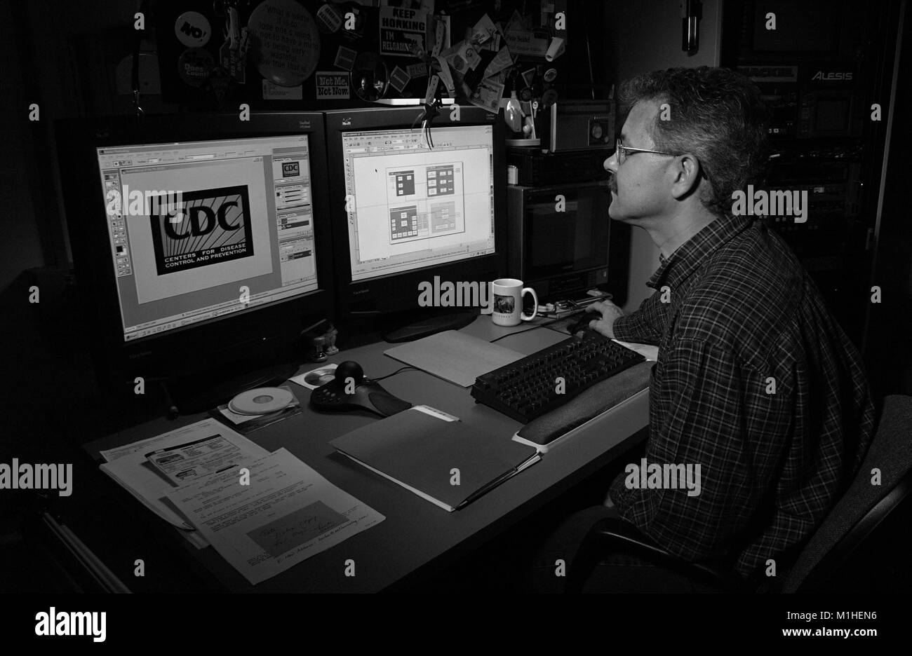 Photograph of Pete Seidel, a computer graphics specialist at the CDC (Acting Branch Chief for the Division of Specialized Media), working at a computer desk on a CDC presentation for the 131st Annual APHA (American Public Health Association) Meeting, 2003. Image courtesy CDC. () Stock Photo