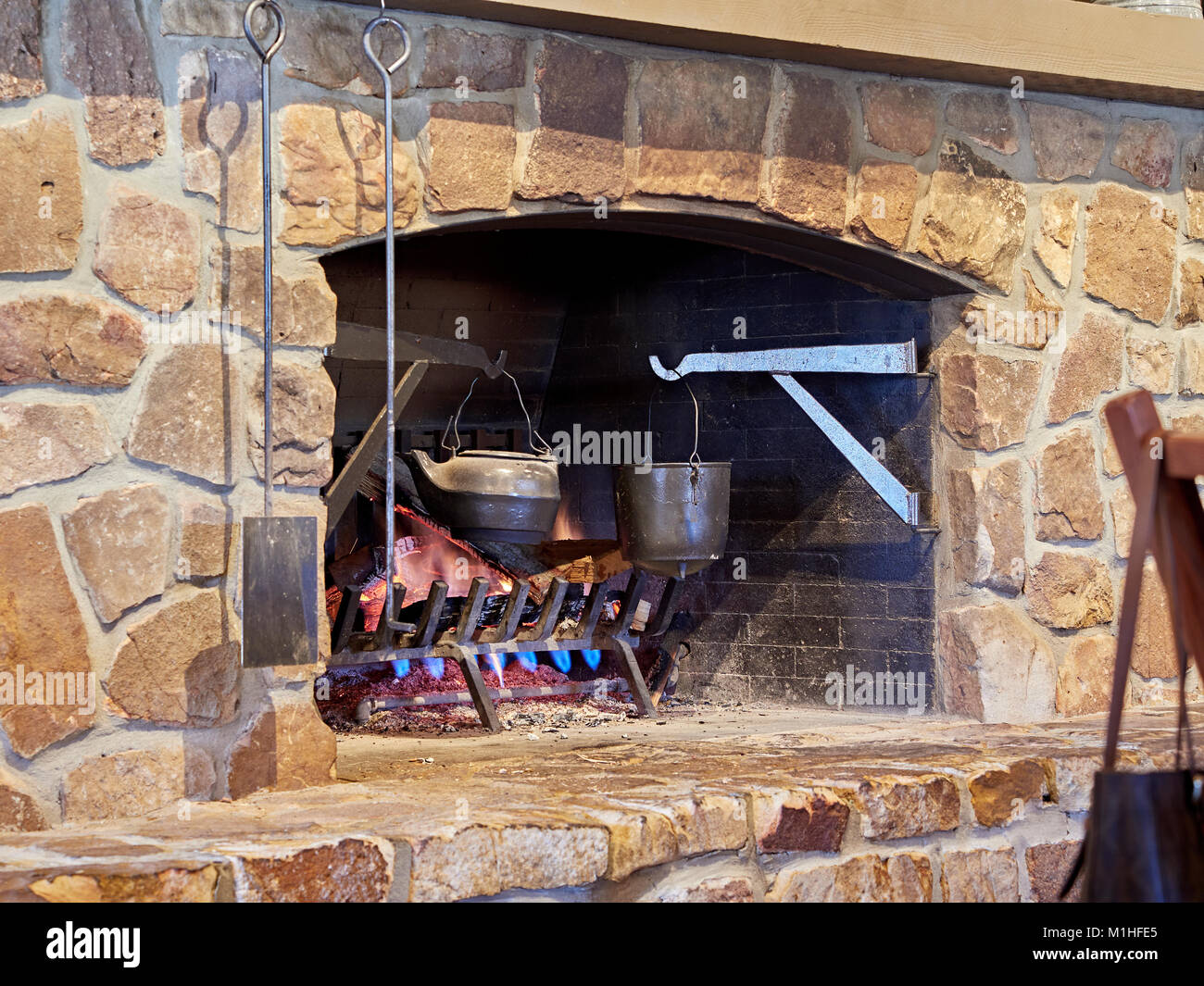 Fireplace in the Cracker Barrel Restaurant with a roaring fire and hanging vintage pots in Montgomery Alabama, United States. Stock Photo