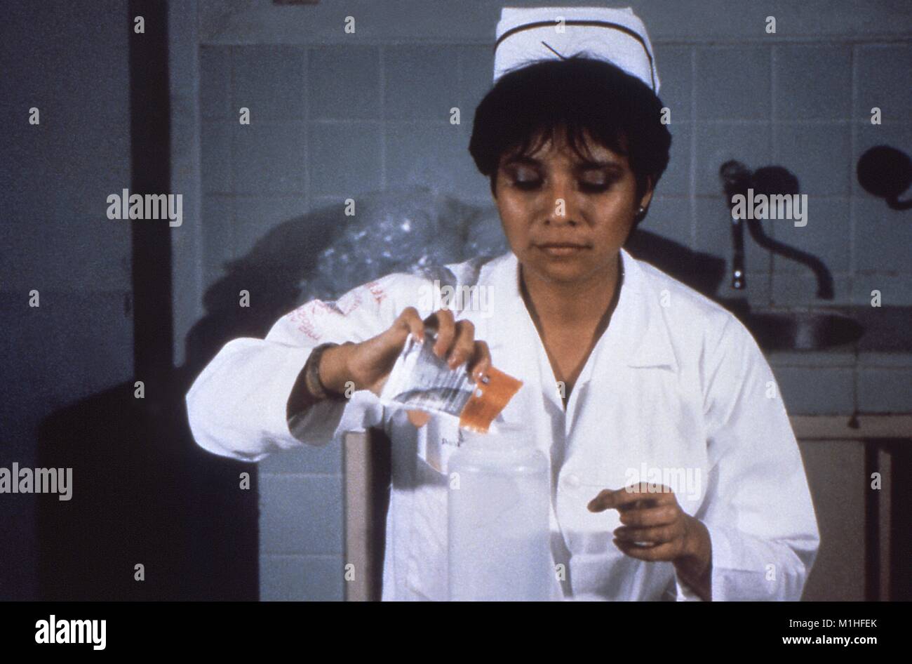 Photograph of a nurse in uniform, preparing an oral rehydration