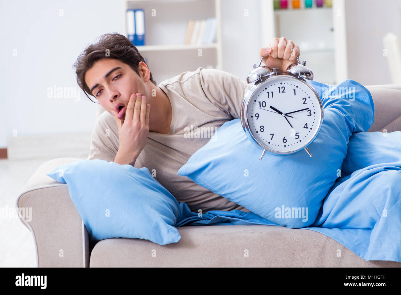 Man having trouble waking up with alarm clock Stock Photo Alamy