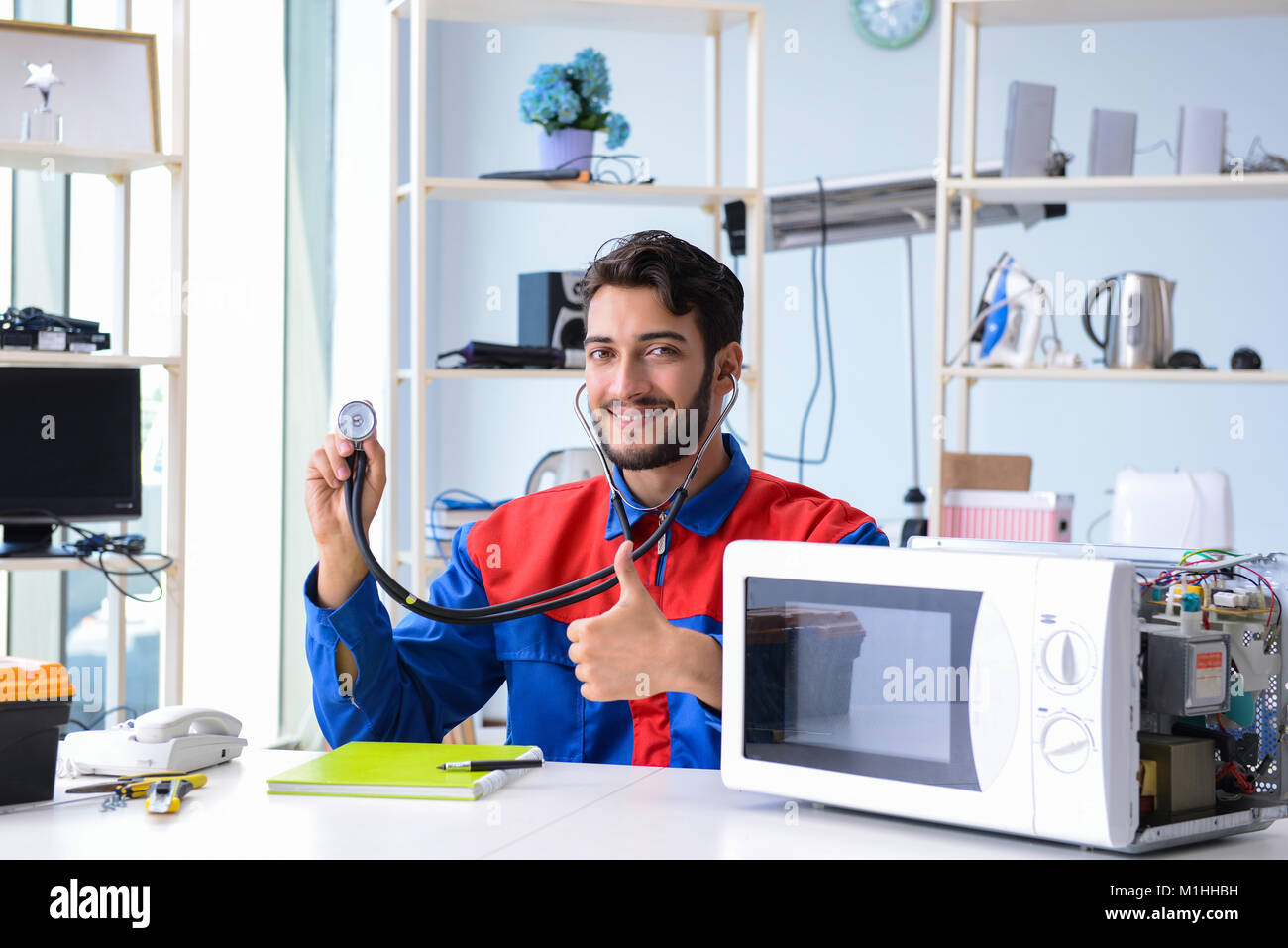 Young repairman fixing and repairing microwave oven Stock Photo Alamy