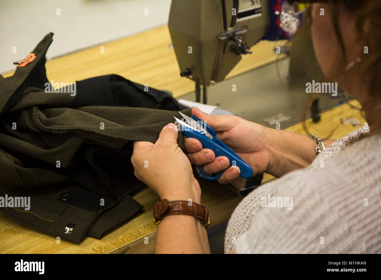 Blanca Quintero, a seamstress at the station drycleaners, alters a pair of U.S. Marine Corps