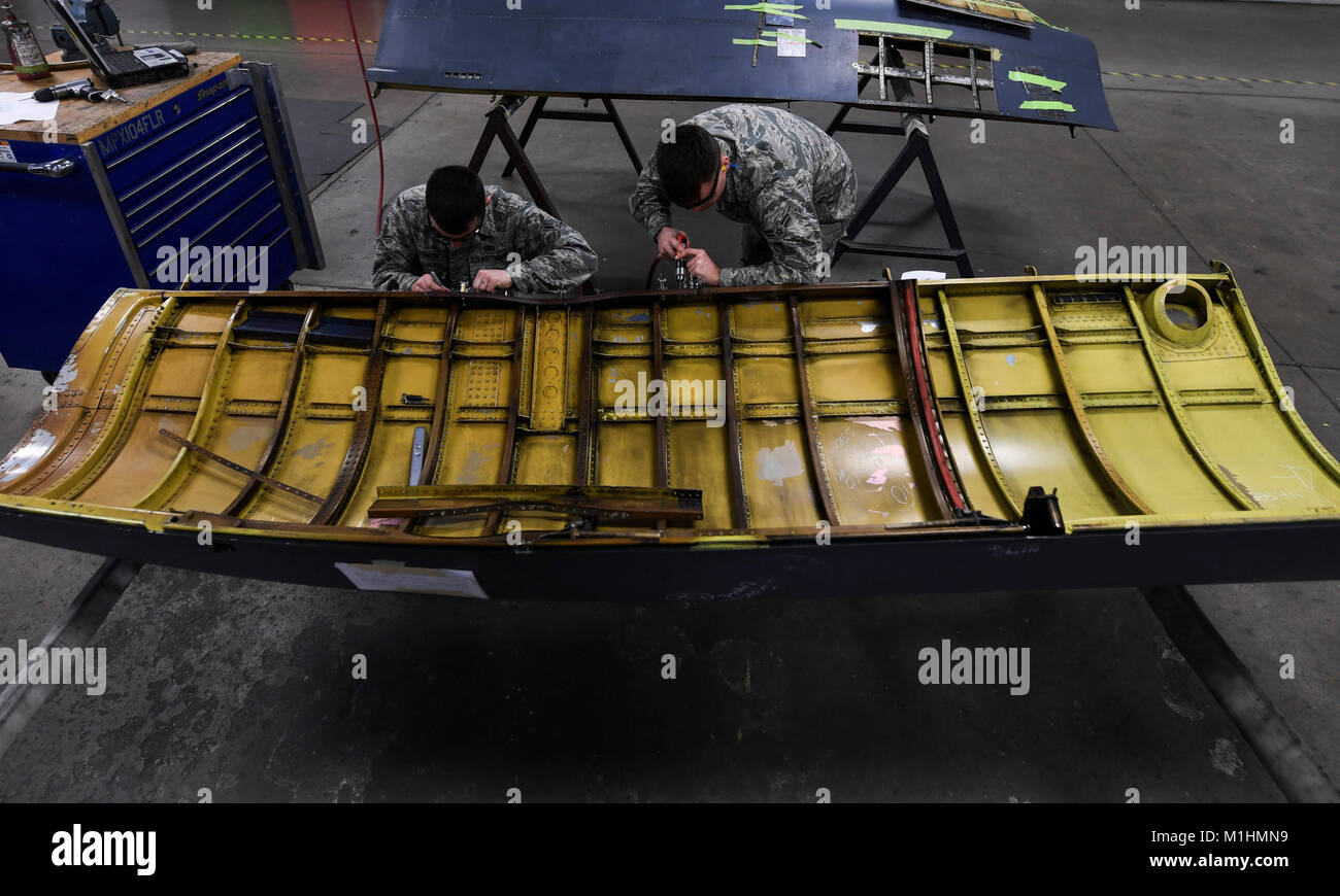 From left, Airman Britain Cutbirth and Airman 1st Class Christopher Rich, 5th Maintenance Squadron aircraft structural maintenance apprentices, perform maintenance on an upper engine cowling at Minot Air Force Base, N.D., Jan. 25, 2018. Airmen with the 5th MXS support the flying mission through munition, aircraft and other maintenance operations. (U.S. Air Force Stock Photo