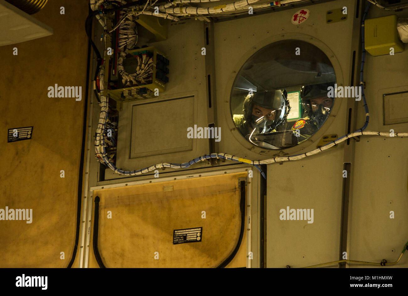 Aircrew members watch the airdrop from the cockpit window during an ...