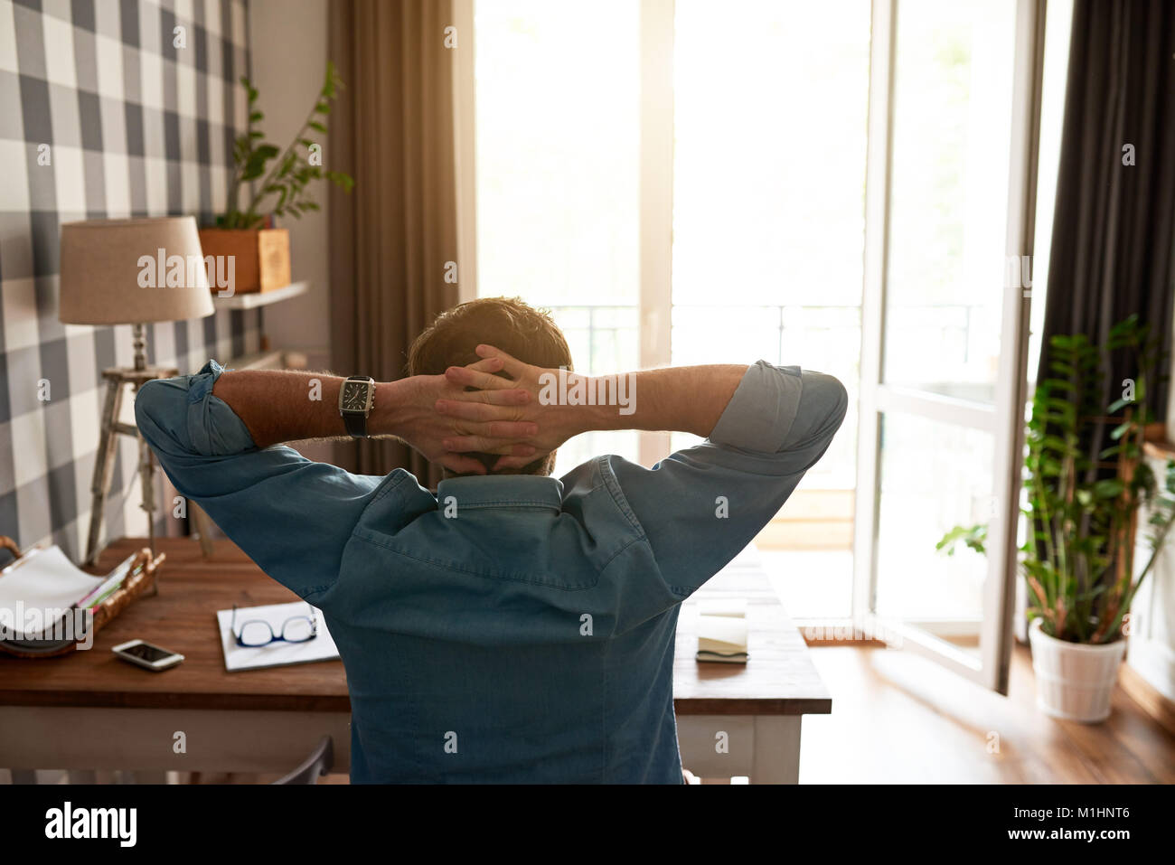 Man leaning back in his chair while working from home Stock Photo Alamy