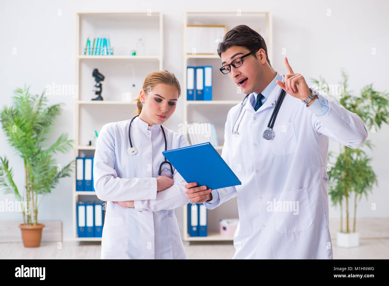 Male and female doctor having discussion in hospital Stock Photo - Alamy
