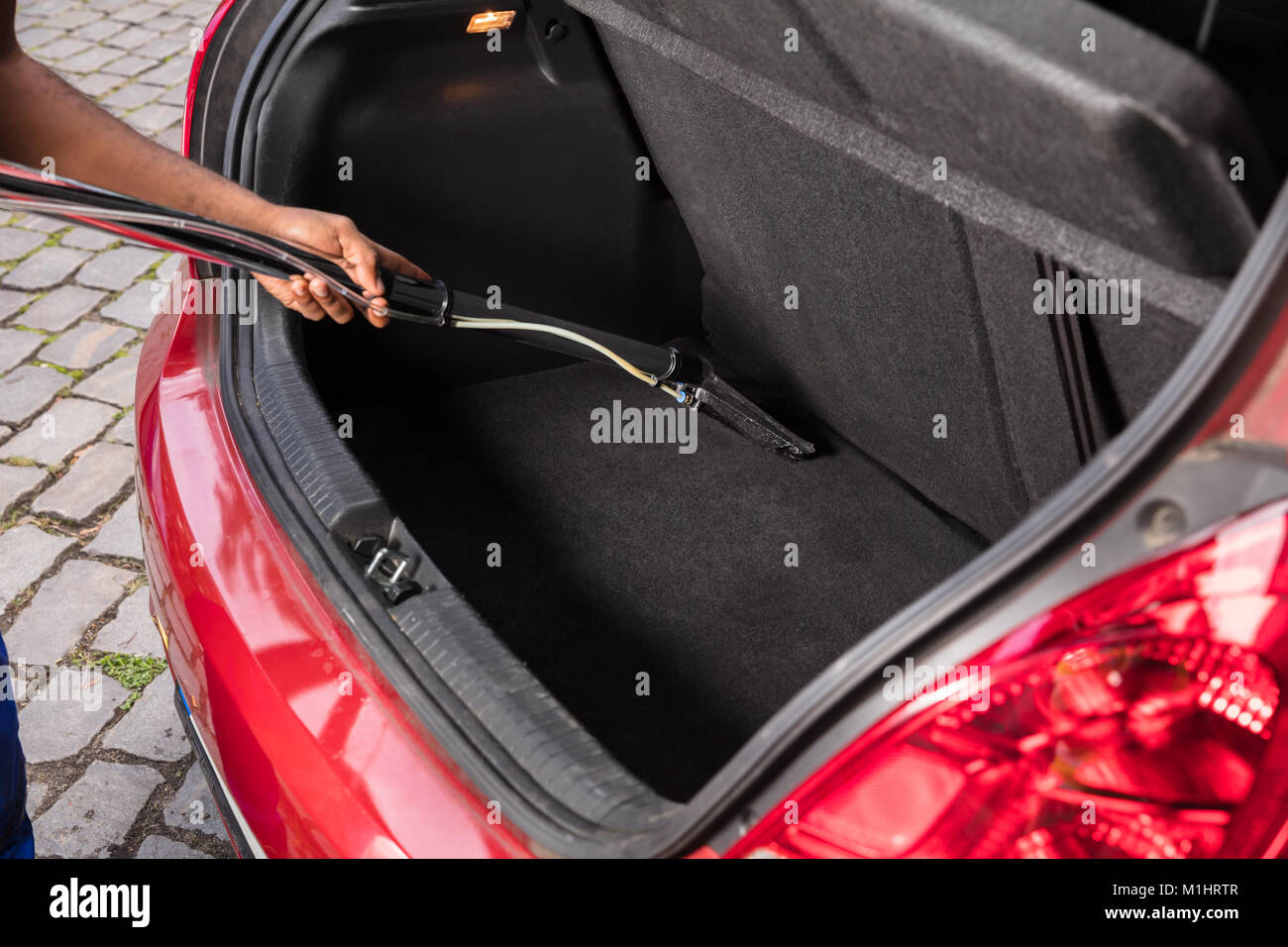 Handyman vacuuming car front textile seat with vacuum cleaner. man cleaning  work machine Stock Photo - Alamy