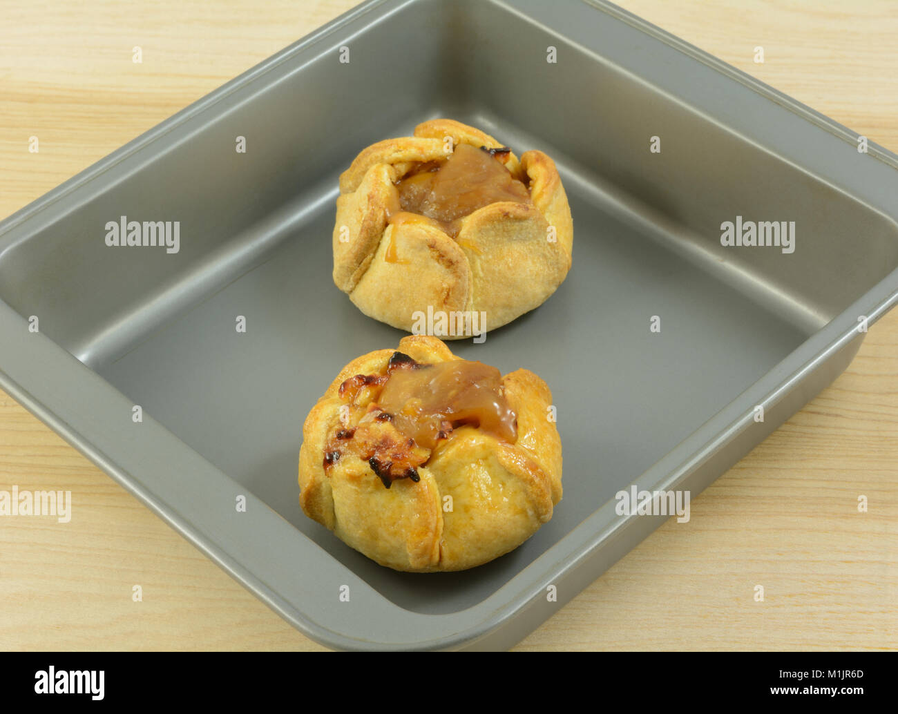 Two frozen apple caramel tarts in non stick baking pan Stock Photo