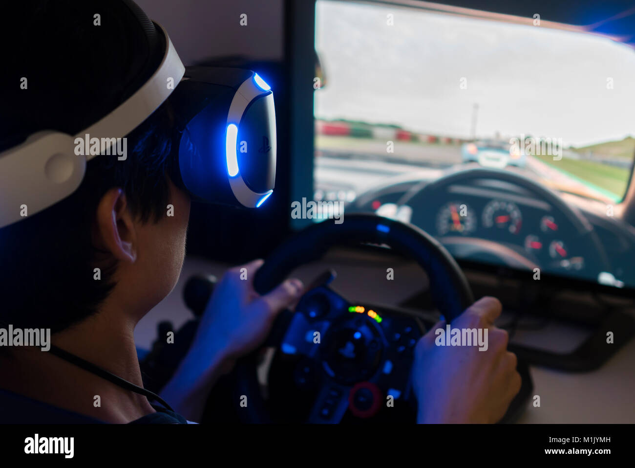 Playing racing video game with VR headset at home Stock Photo