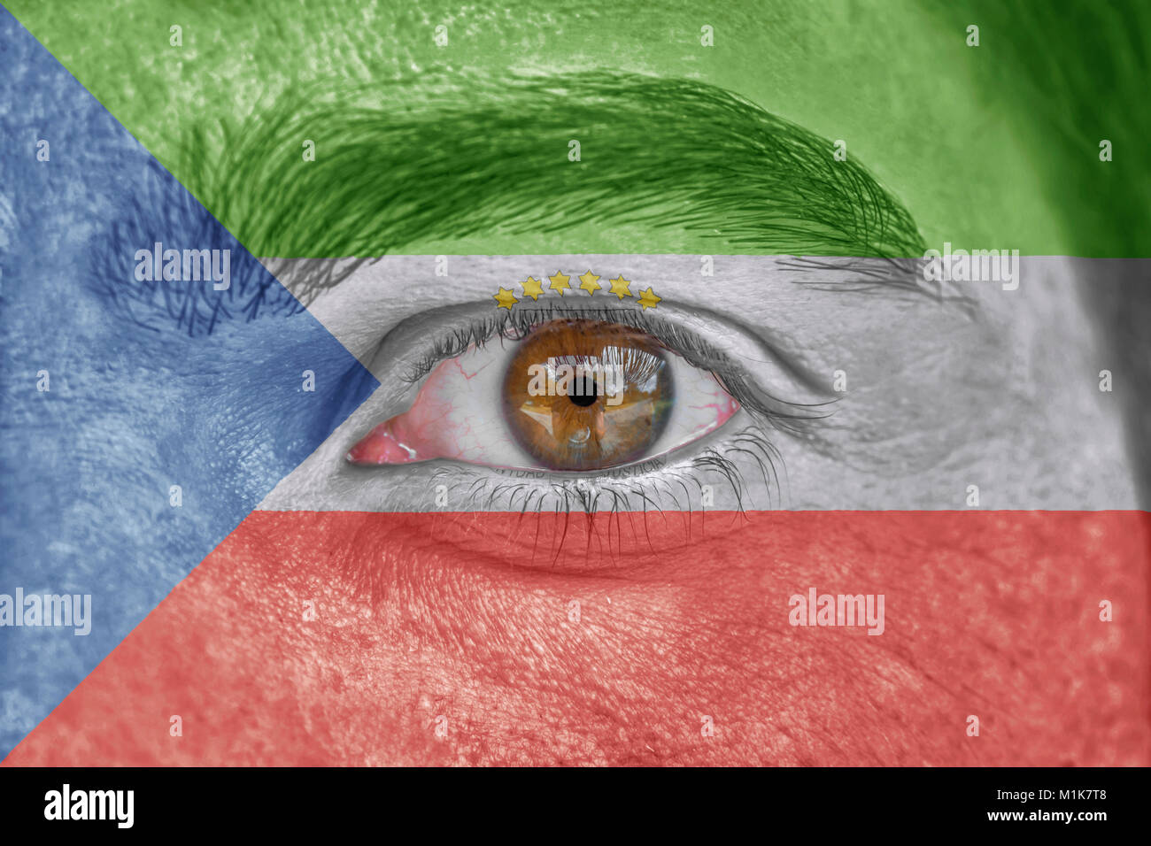 Human face and eye painted with flag of Equatorial Guinea Stock Photo