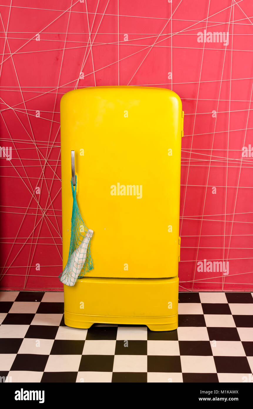 yellow old vintage retro refrigerator on a pink background with string