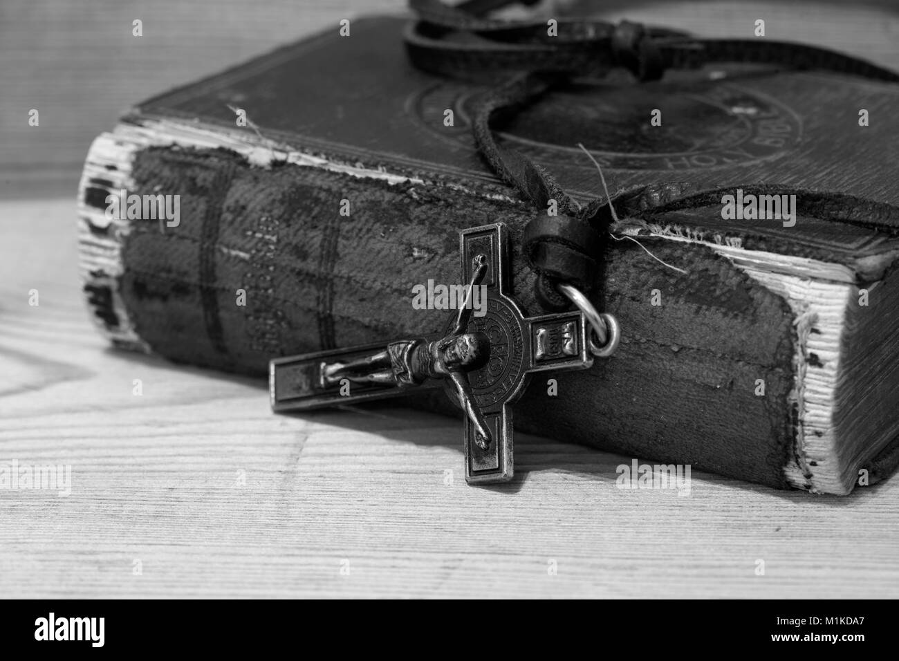Crucifix necklace on a bible with wood background in black and white Stock Photo