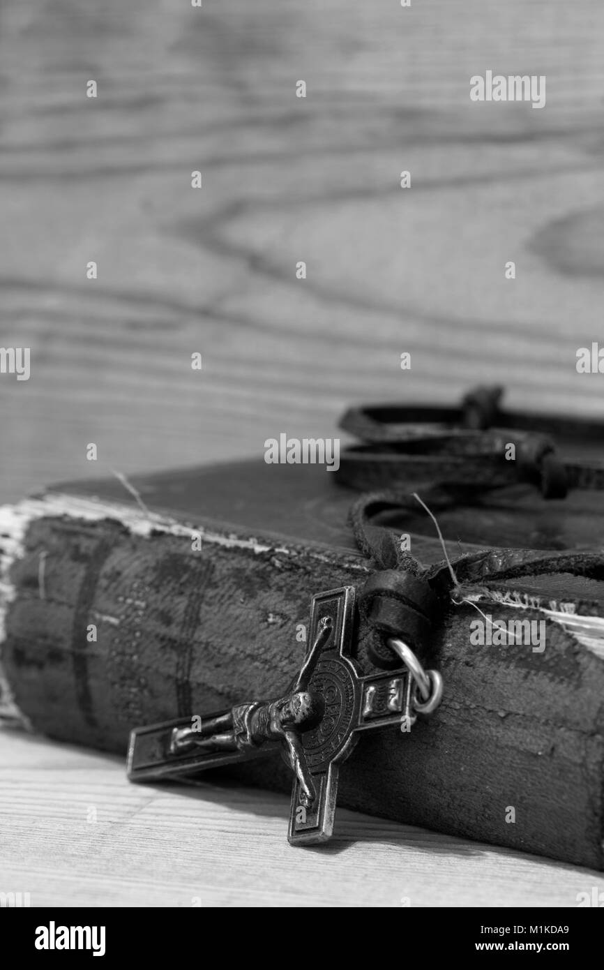 Crucifix necklace on a bible with wood background in black and white Stock Photo