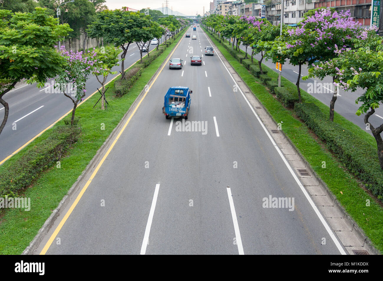 Cars driving on the asphalt highway lined by traffic island trees, Huanhe Expressway, Wanhua District, Taipei City, Taiwan Stock Photo