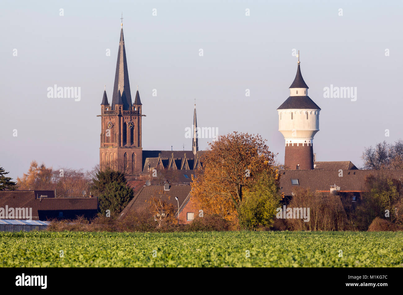 Krefeld-Hüls, Katholische Pfarrkirche St. Cyriakus, Davor der Wasserturm Stock Photo