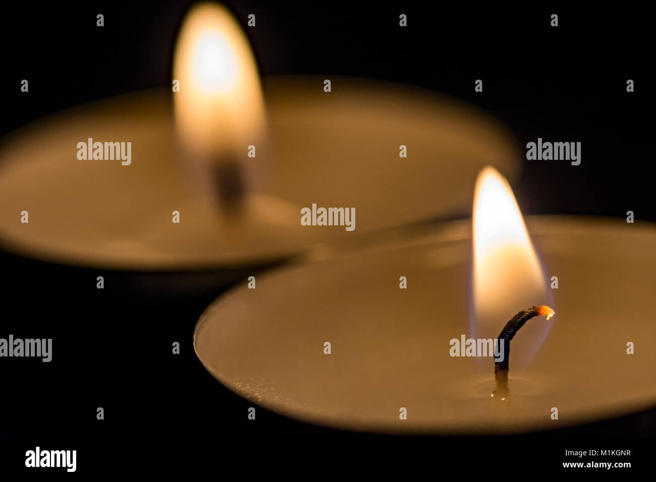 two burning candles in black background Stock Photo - Alamy
