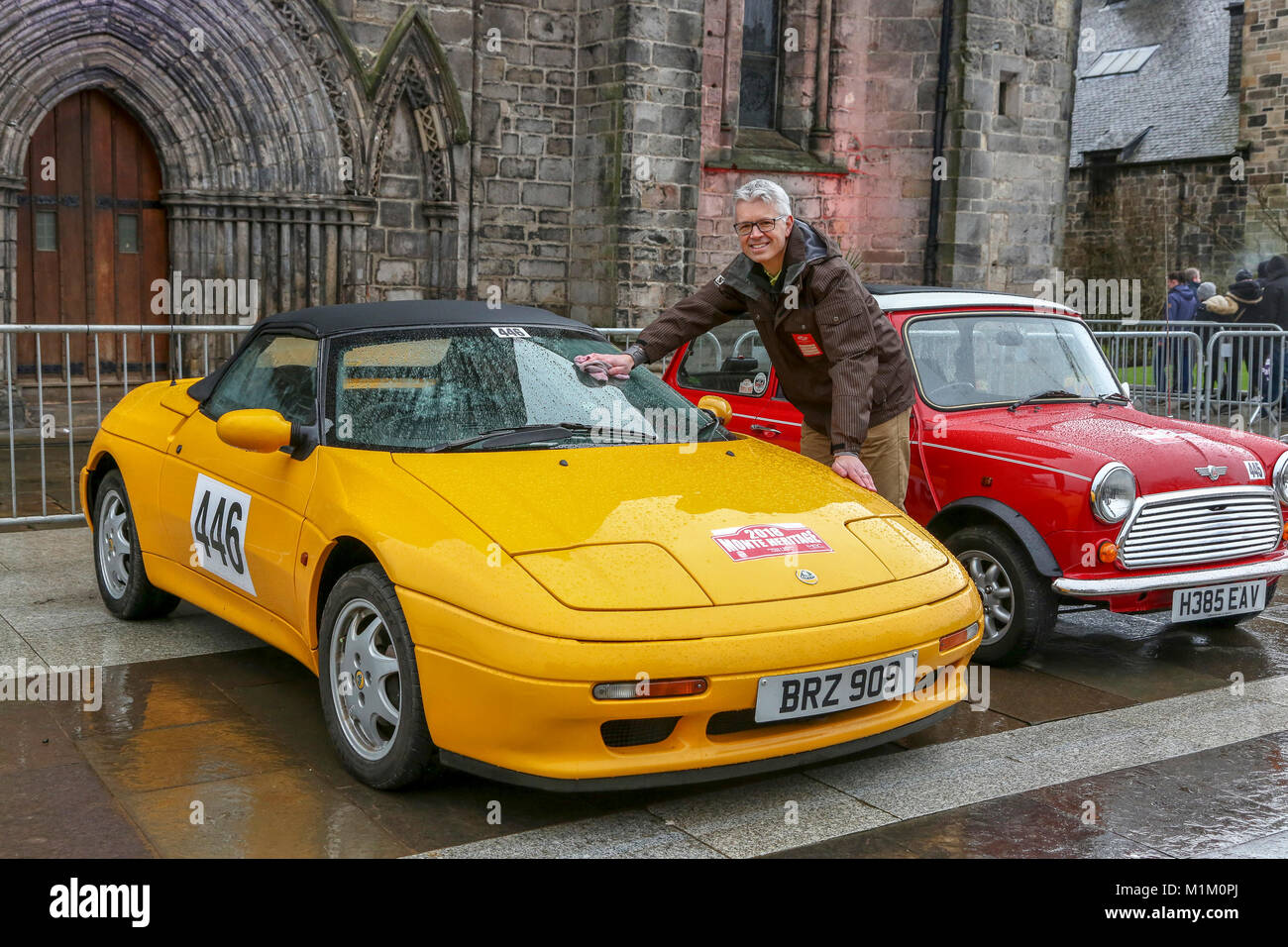 Paisley, Scotland, UK. 31st January, 2018. On a cold and sometimes very wet January day, 1000's of spectators turned out at Paisley Abbey, Renfrewshire to cheer off the 79 national and international entrants to the 2018 Rallye Monte Carlo Historique. Image of COLIN BRUCE from Prestwick, Ayrshire cleaning the windscreen of his 1991 Lotus Elan SE Credit: Findlay/Alamy Live News Stock Photo