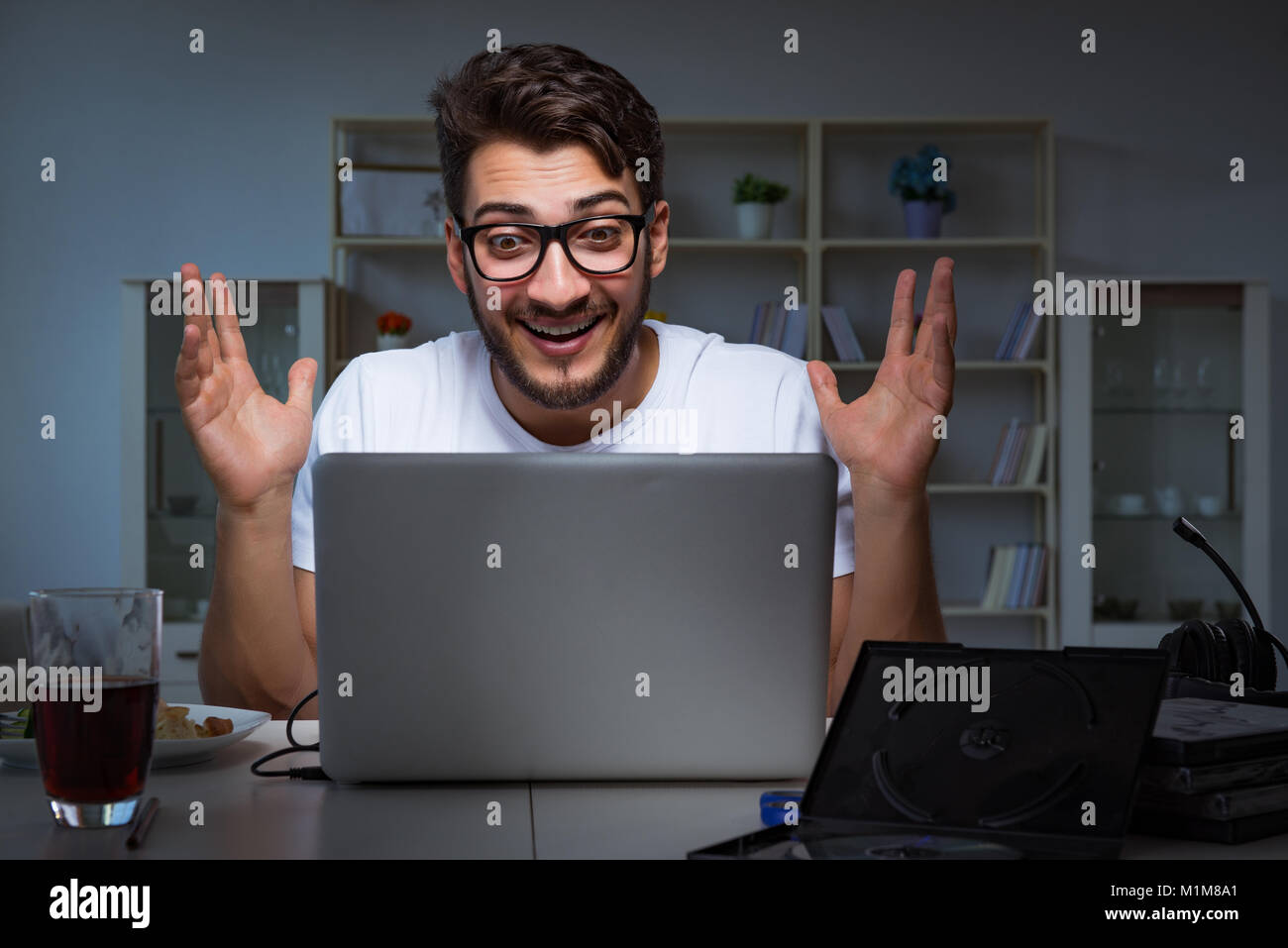 Young man staying late in office to do overtime work Stock Photo