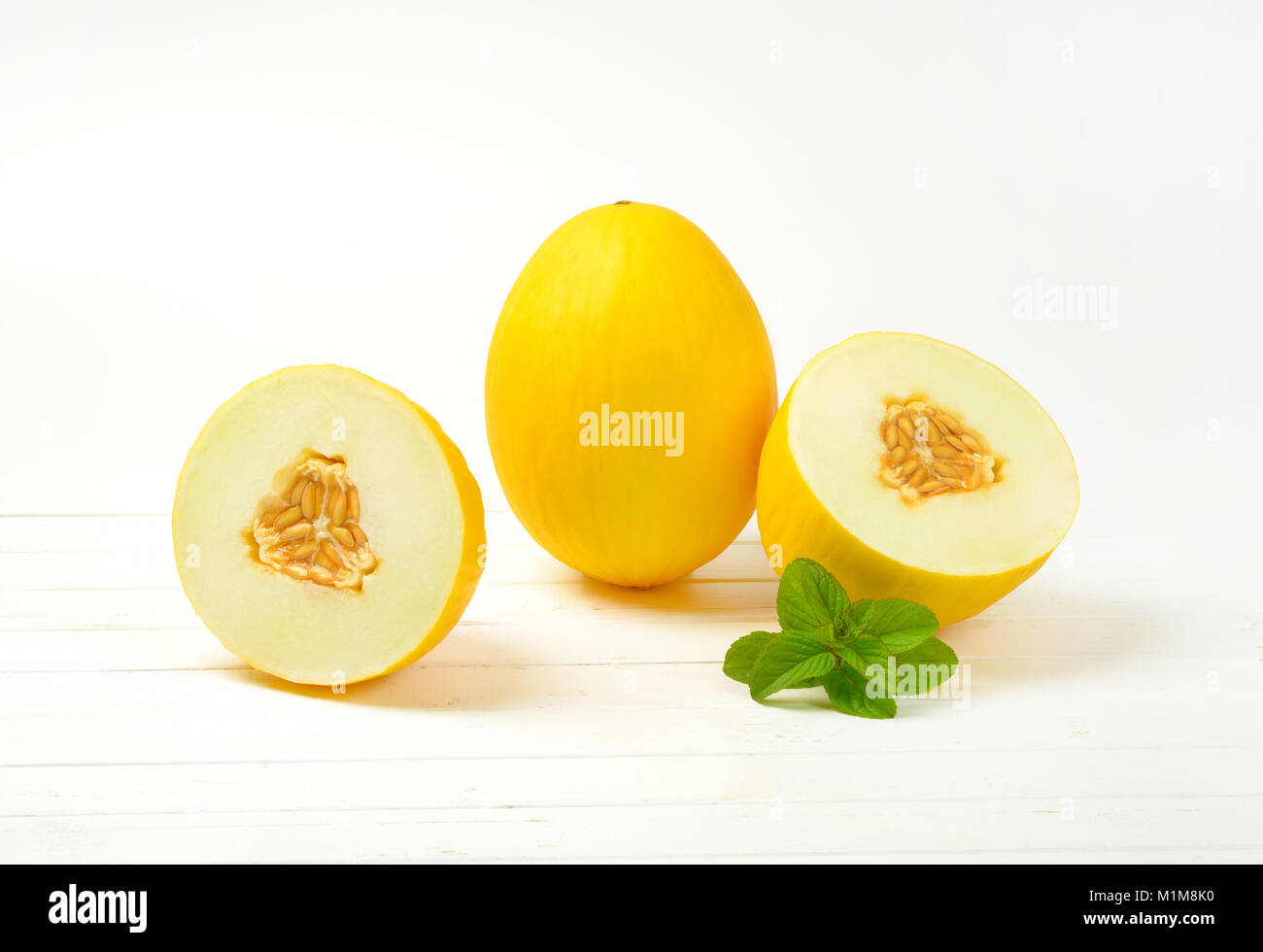 whole and halved yellow melons Stock Photo