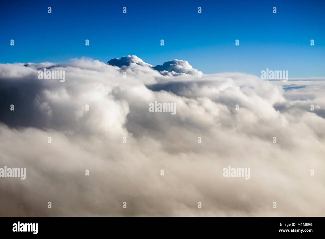 Aerial view over cumulus clouds from an airplane window during the ...